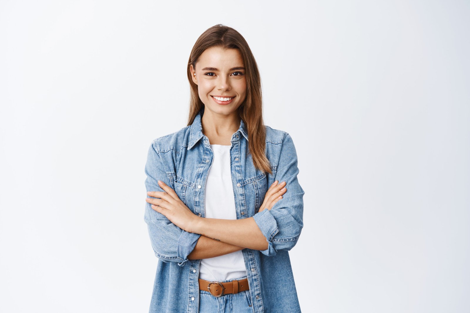 Portrait of smiling confident woman feeling ready and determined, cross arms on chest self-assured looking at camera, standing against white background.